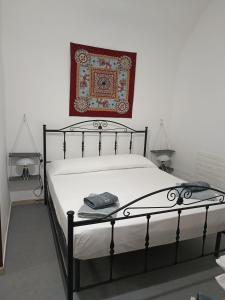 - une chambre avec un lit et un tapis sur le mur dans l'établissement NONNA ADRIANA, à Terrasini