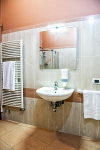 a bathroom with a sink and a mirror and towels at CallMe Crema - Struttura in centro storico in Crema