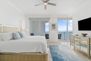 um quarto com uma cama e uma televisão de ecrã plano em Palacio Penthouse 1902 em Perdido Key