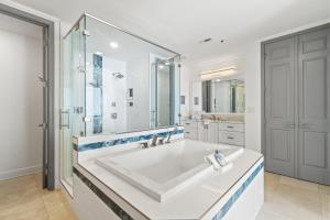 uma casa de banho branca com uma grande banheira e um chuveiro em Palacio Penthouse 1902 em Perdido Key