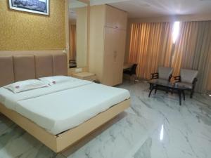 a bedroom with a large bed and a living room at Vits Select Grand Inn, Ratnagiri in Ratnagiri