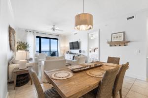 uma sala de jantar e sala de estar com mesa e cadeiras em Grand Pointe 401 em Orange Beach