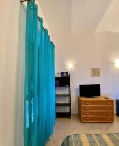 Habitación con escritorio y cortina azul en Casa Vacanze Torre di Mola, en Formia