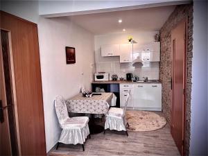 a small kitchen with a table and two chairs at Homestay Renata in Nová Lesná