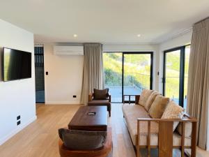 a living room with a couch and a table at Stunning Lakeview Holiday House Queenstown in Frankton Wharf