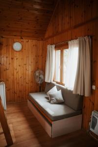 Habitación con cama, ventana y ventilador. en Camping Alquézar, en Alquézar