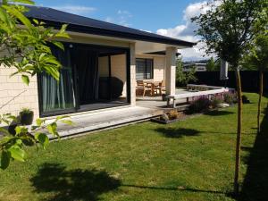 a house with a porch with a bench and a table at 10 @ Wai Matangi in Turangi