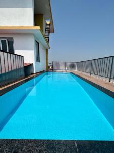 a large blue swimming pool next to a building at Lar De Oliveira in Porvorim