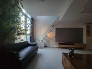 a living room with a couch and a flat screen tv at Chaoyang Joy City Hardcover Apartment in Beijing