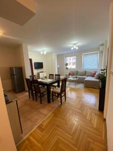 a kitchen and living room with a table and chairs at D Apartment Free private Parking in Novi Sad