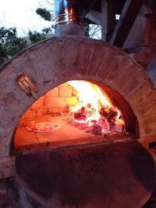 a brick oven with a pizza in it at Home of art in Râşnov