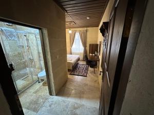 a room with a shower and a bedroom with a bed at Virtus Cappadocia Hotel Göreme in Göreme