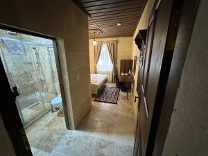 a room with a shower and a bedroom with a bed at Virtus Cappadocia Hotel Göreme in Goreme +217 photos