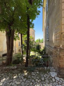 un edificio con una puerta y árboles en un patio en Casa Otto, en Fara in Sabina