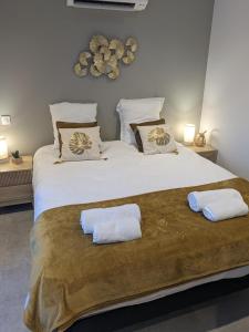 - un grand lit avec 2 serviettes blanches dans l'établissement T2 bord de mer avec garage, à Collioure