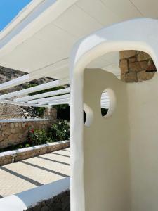 a white house with a staircase with a white roof at Milo Milo Suites in Mandrakia