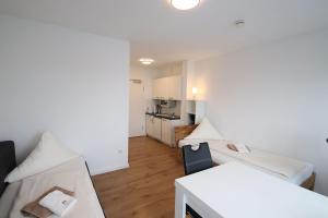 アシャッフェンブルクにあるApartments/Wohnungen direkt in Aschaffenburgのベッド2台とキッチンが備わる小さな客室です。