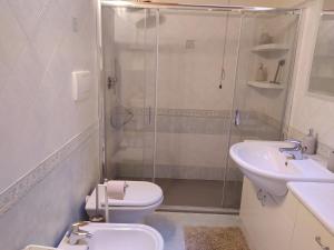 uma casa de banho com um chuveiro, um WC e um lavatório. em Villetta di montagna em Foza