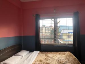 A bed or beds in a room at Krishna Inn