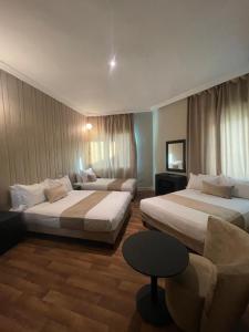 卡萨布兰卡Cadé Hotel的有两张床和一张沙发的酒店房间