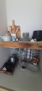 una estantería de madera con platos y utensilios. en Beachview Guest Suites Port Elizabeth, en Beach View