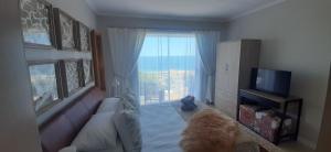 sala de estar con sofá y ventana en Beachview Guest Suites Port Elizabeth, en Beach View