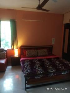 a bedroom with a bed and a couch and a window at Royale Seaward Supreme in Chennai