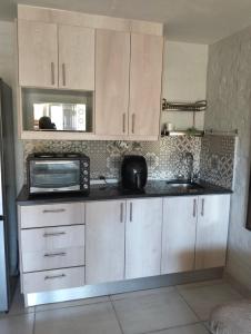 a kitchen with a microwave oven and a sink at Mountain view in George