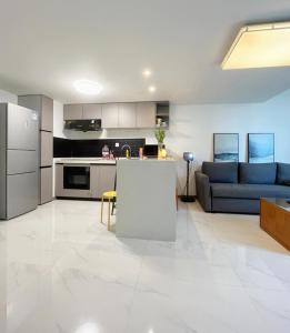 uma ampla sala de estar com um sofá e uma cozinha em Chaoyang Joy City Hardcover Apartment em Pequim