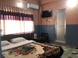 A bed or beds in a room at Krishna Inn