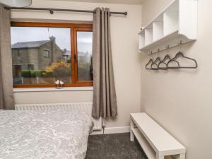 - une chambre avec un lit et une fenêtre dans l'établissement The Robins Holiday Cottage, à Keighley