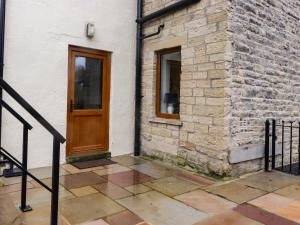 - un bâtiment avec une porte en bois et une fenêtre dans l'établissement The Robins Holiday Cottage, à Keighley