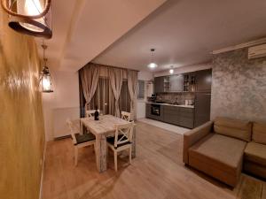 une cuisine et un salon avec une table et un canapé dans l'établissement Park Residence 5, 2 Bedroom Apartment, à Bucarest