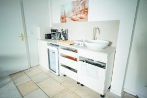 a white kitchen with a sink and a counter at Kingsize Bett, Nahe Stadt und Alster, Ruhig in Hamburg