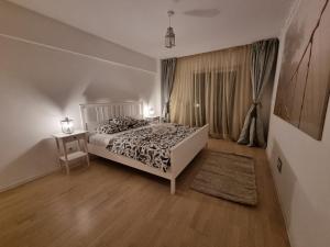 - une chambre avec un lit et une table avec une table de chevet dans l'établissement Park Residence 5, 2 Bedroom Apartment, à Bucarest
