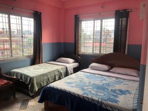 A bed or beds in a room at Krishna Inn