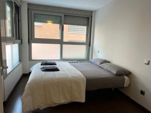 a bed in a room with two windows at Amplio apartamento a 15 minutos de la puerta del Sol in Madrid +22 photos