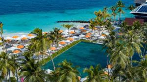 - une vue aérienne sur la piscine du complexe avec des parasols et l'océan dans l'établissement OBLU XPERIENCE Ailafushi - All Inclusive with Free Transfers, à Malé