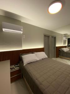 1 dormitorio con cama grande y luz en Apartamento Av. Atlântica, com vista mar., en Balneário Camboriú