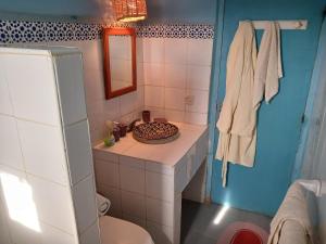y baño con aseo, lavabo y espejo. en chambre d'hôte yamina en Tafraoute