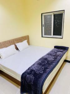 łóżko w pokoju z oknem w obiekcie Shree Govindam Guest House w mieście Ujjain