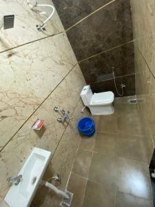 La salle de bains est pourvue d'un lavabo et de toilettes. dans l'établissement Shree Govindam Guest House, à Ujjain