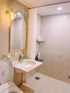 een badkamer met een wastafel, een toilet en een spiegel bij ypark in Seoul
