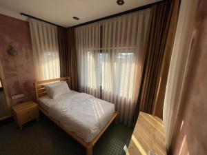 niewielka sypialnia z łóżkiem i oknem w obiekcie BKM Hostel w Stambule