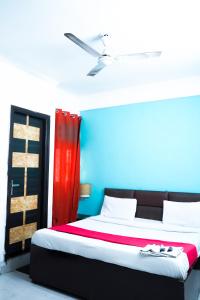 1 dormitorio con 1 cama con pared roja y azul en Family Friendly Hotel - Near Saket Metro, en Nueva Delhi