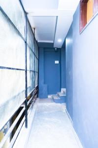 un pasillo con una puerta azul en un edificio en Family Friendly Hotel - Near Saket Metro, en Nueva Delhi