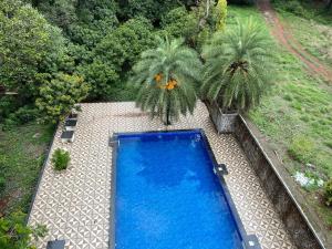 een uitzicht over een blauw zwembad in een tuin bij Bel-Air Ayurveda Resort in Panchgani