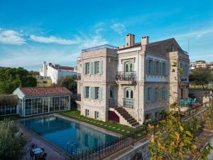 a large house with a swimming pool in front of it at Naz Su Cunda in Cunda