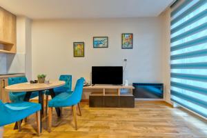 a dining room with a table and blue chairs at Apartman Ivana Vila Elza in Zlatibor