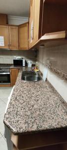 a kitchen with a sink and a granite counter top at Recanto do Algarve in Olhão